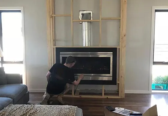 Technician working on a modern Fireplace Remodeling project, showing the steps of building it.